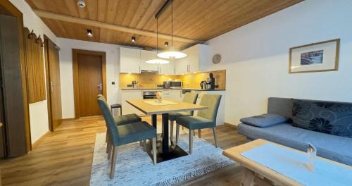 a kitchen and living room with a table and a couch at Apart - und Frühstückspension Jägerheim in Kaunertal