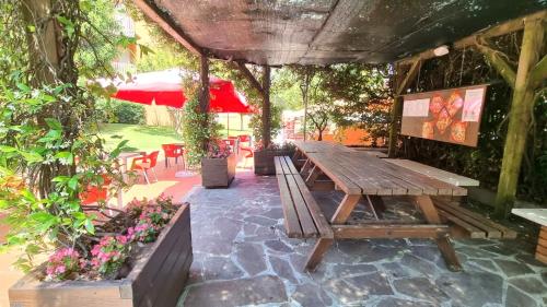 a wooden picnic table in a patio with flowers at Casa Carla in Peschiera del Garda
