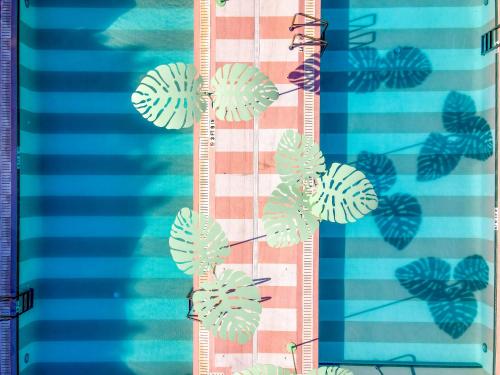 a group of green leaves on a striped towel at The Goodtime Hotel, Miami Beach a Tribute Portfolio Hotel in Miami Beach