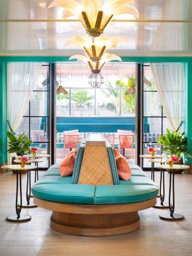 a bed in the middle of a room with windows at The Goodtime Hotel, Miami Beach a Tribute Portfolio Hotel in Miami Beach