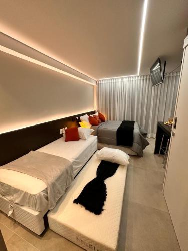 a bedroom with two beds with a black cat laying on the floor at RN STUDIO PREMIUM Ap 321 in Maceió