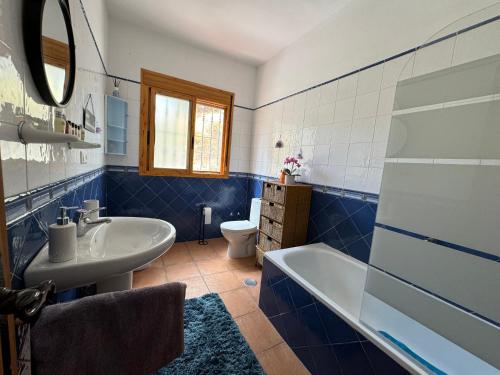 a blue and white bathroom with a tub and a sink at Casa Wenne - Private Pool with view in Sedella