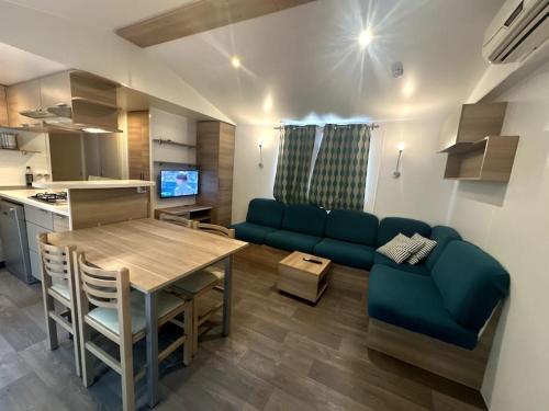 un salon avec une table et un canapé bleu dans l'établissement Cottage Domaine Privé - Sud de France - Jacuzzi, à Le Cailar