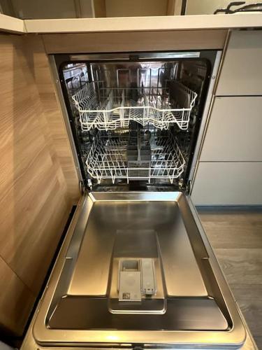 un lave-vaisselle vide avec un panier de fil dans l'établissement Cottage Domaine Privé - Sud de France - Jacuzzi, à Le Cailar