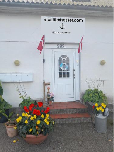 a front door of a house with flowers in pots at Holiday apartment & boat rental in Sindal