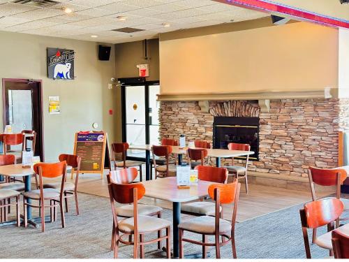 a restaurant with tables and chairs and a fireplace at Holiday Inn Hotel & Suites Regina by IHG in Regina