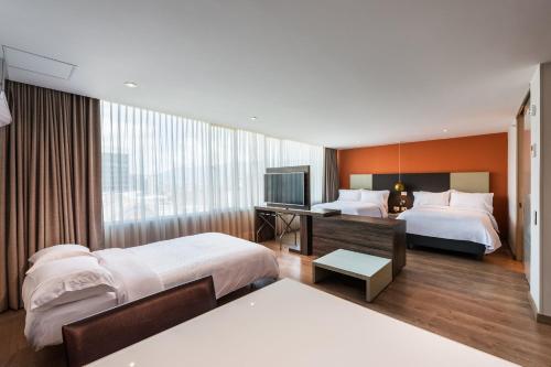 a hotel room with two beds and a television at Hotel Holiday Inn Express & Suites Medellin by IHG in Medellín
