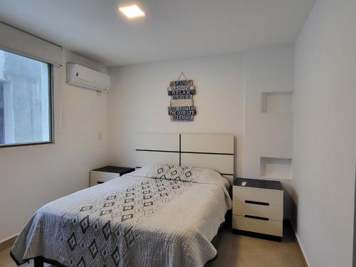 a white bedroom with a bed and a window at SUITES BRISAMAR PLAYA SANTA MARIANITA Manta in Manta