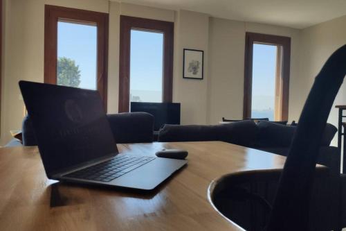 a laptop computer sitting on a wooden table in a living room at Stylish Triplex Apartment in The Heart of Izmir in Konak