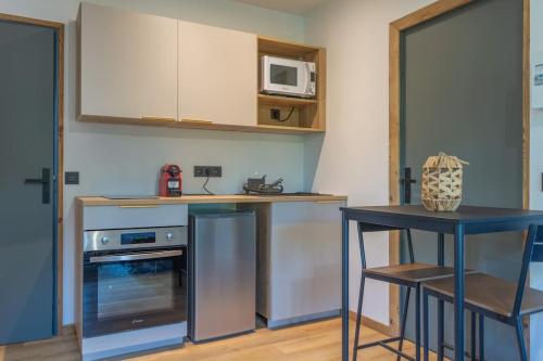 a kitchen with a counter and a table and a microwave at Studio Miloé secteur TMB in Saint-Gervais-les-Bains