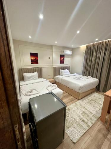 a hotel room with two beds and a television at Radiant Pyramids View in Cairo