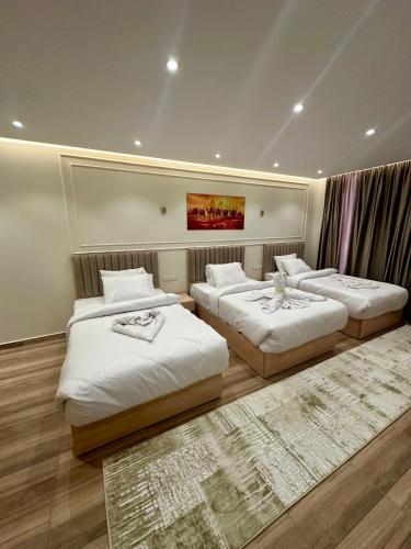 a room with three beds and a rug at Radiant Pyramids View in Cairo