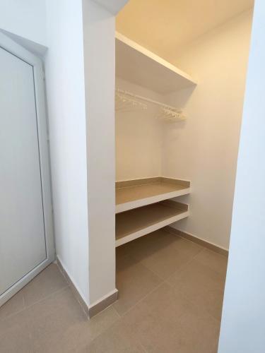 a walk in closet with white walls and shelves at Villa Azurina in Fumba