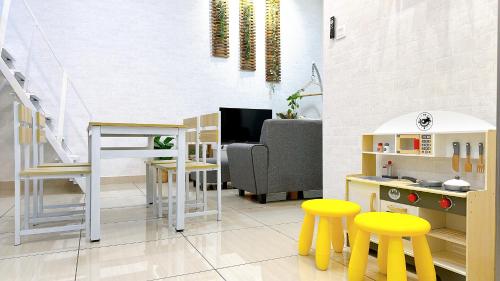 a living room with a play kitchen and yellow stools at Mount Austin Manhanttan Sovo by Cactus Homestay in Johor Bahru