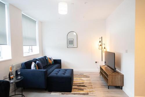 a living room with a blue couch and a tv at Luxury 1-Bed Flat - Free Parking in Solihull