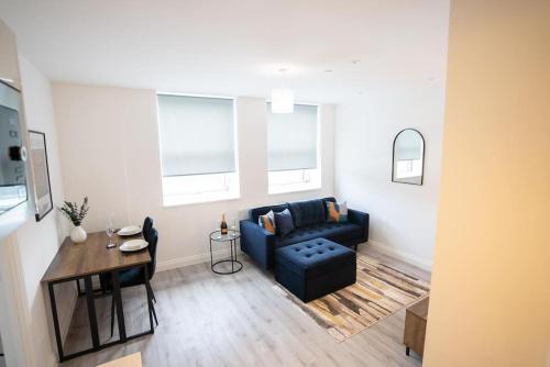a living room with a blue couch and a table at Luxury 1-Bed Flat - Free Parking in Solihull