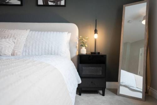 a bedroom with a white bed and a mirror at Luxury 1-Bed Flat - Free Parking in Solihull