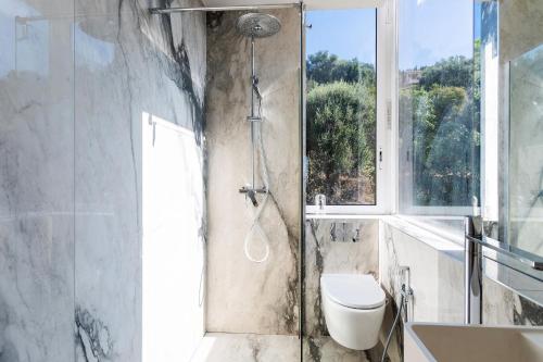 une salle de bain avec douche, toilettes et fenêtre dans l'établissement LE MIRAMAR AP4426 By Riviera Holiday Homes, à Villefranche-sur-Mer
