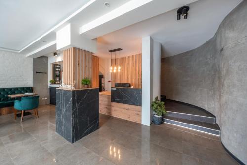 una hall con ufficio e grande parete di cemento di Garni Hotel Mediteraneo a Novi Sad