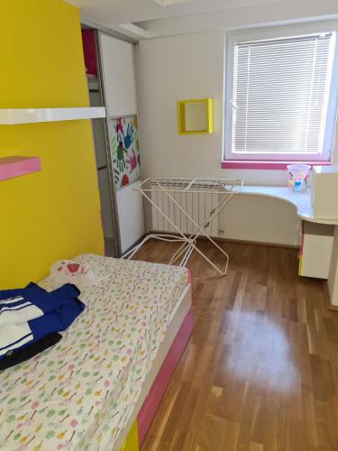 a bedroom with a bed and a table and a window at Villa Kale Luxury in Skopje