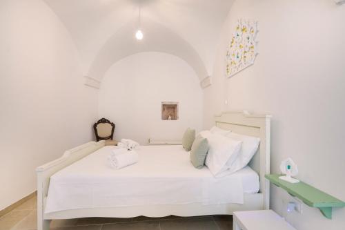 een witte slaapkamer met een wit bed en een groene tafel bij Giona's guest house by IL PUMO DI PUGLIA in Martina Franca