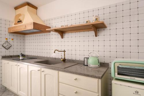 een keuken met een spoelbak en een magnetron bij Giona's guest house by IL PUMO DI PUGLIA in Martina Franca