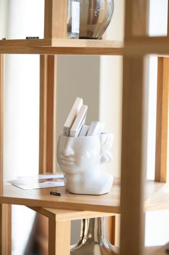 a white container of utensils sitting on a shelf at INNSiDE by Meliá Prague Old Town in Prague