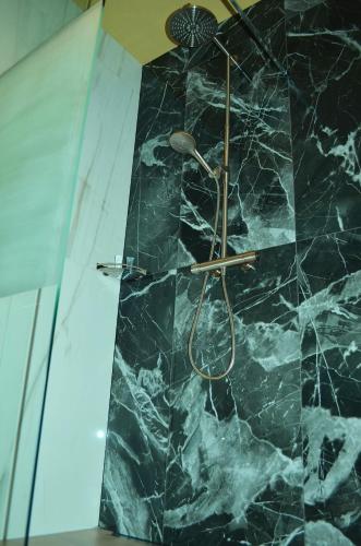 a bathroom with a shower with a marble wall at Bed en Breakfast Peterman in Groenlo