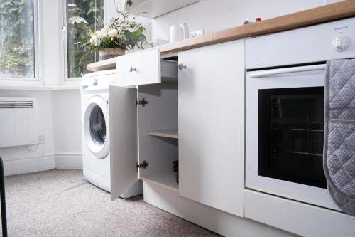 a white laundry room with a washer and dryer at Stylish Swindon Town Centre Apartment, FREE parking, sleeps up to 3 in Swindon