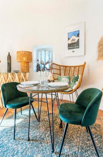 une salle à manger avec une table et deux chaises vertes dans l'établissement Moulin Rouge Provençal Suite Premium avec jacuzzi extérieur, à Bouc-Bel-Air