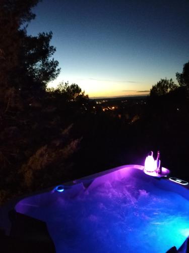 - une piscine éclairée la nuit avec une bougie dans l'établissement Moulin Rouge Provençal Suite Premium avec jacuzzi extérieur, à Bouc-Bel-Air