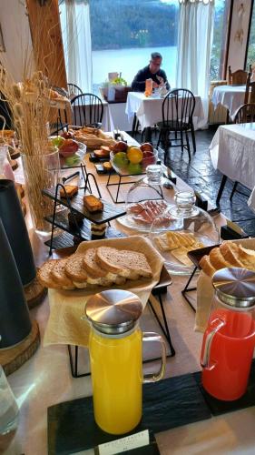 un tavolo per la colazione con pane, succo e pane di Hosteria El Condado a San Carlos de Bariloche