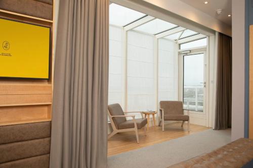 a room with two chairs and a table and a window at voco St. David's Cardiff by IHG in Cardiff