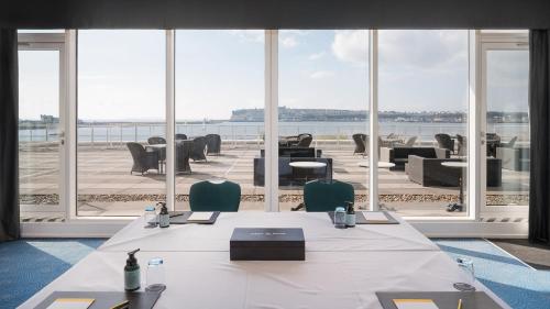 a meeting room with a table and chairs and a large window at voco St. David's Cardiff by IHG in Cardiff