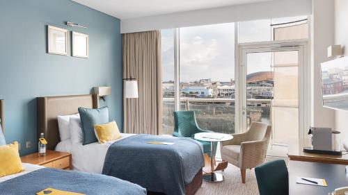 a hotel room with two beds and a window at voco St. David's Cardiff by IHG in Cardiff