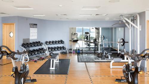 a gym with several treadmills and exercise machines at voco St. David's Cardiff by IHG in Cardiff