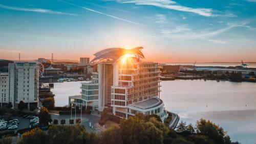 a city skyline with the sun shining on a building at voco St. David's Cardiff by IHG in Cardiff