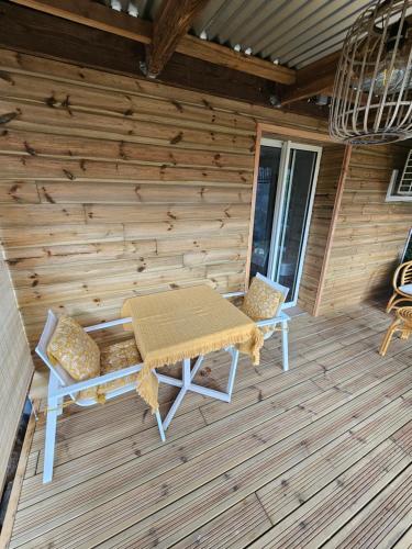 a picnic table and two chairs on a wooden deck at LODGE INDIGO - Bungalow & RDC indépendant proche aéroport in Sainte-Marie