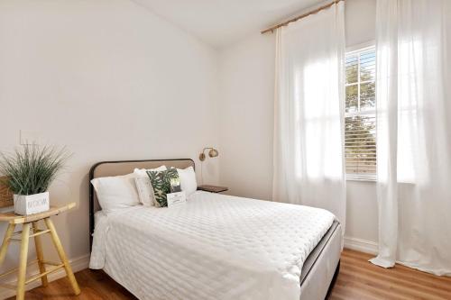 a white bedroom with a bed and a window at Banana Leaf Villa-Marley Junior Suite in Orlando