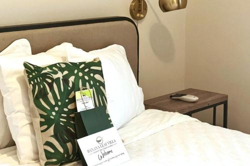 a bed with a sign on it next to a table at Banana Leaf Villa-Marley Junior Suite in Orlando
