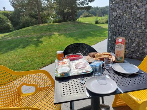 a table with plates and food on top at TIME-OUT met ZONNIG TERRAS, eigen KEUKEN, Dichtbij Dorp, Duinen, Strand en Vuurtoren , Incl verwarmd Hotel-ZWEMBAD in Hollum