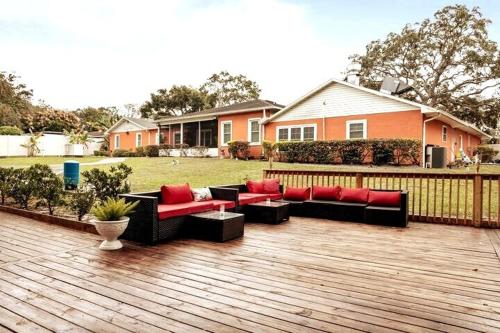 a patio with couches and tables on a wooden deck at Banana Leaf Villa-Marley Junior Suite in Orlando