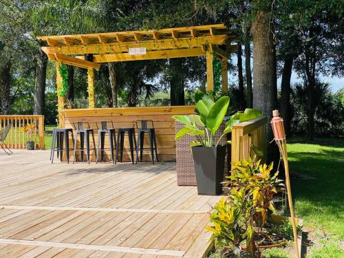 a wooden deck with a bar with stools on it at Banana Leaf Villa-Marley Junior Suite in Orlando