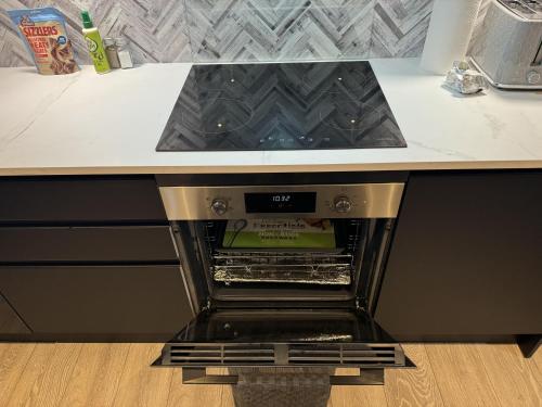 an oven with its door open in a kitchen at Cozy Apartment in Stoke-on-Trent One double bed in Stoke on Trent