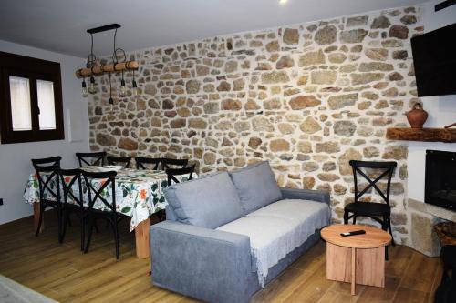 a living room with a couch and a stone wall at Alojamiento Rural La Josefa de los Arribes in Fermoselle