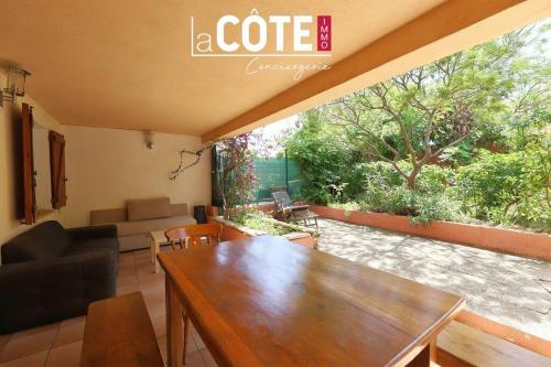 un salon avec une table et un canapé dans l'établissement Le Bayle, à Sausset-les-Pins