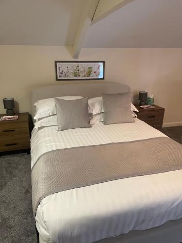 a bedroom with a large white bed with pillows at The Castle Inn in Usk