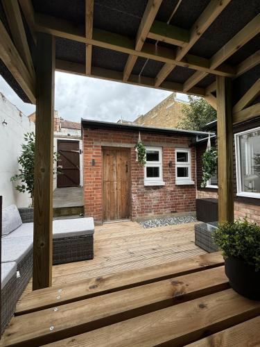 a wooden patio with a wooden pergola at Coastal Comfort Seaside Cabin with Spacious Garden in Margate