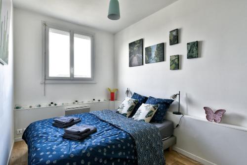 a bedroom with a bed with blue sheets and a window at Spacieux & Familial 3 chambres proche gare in Saumur