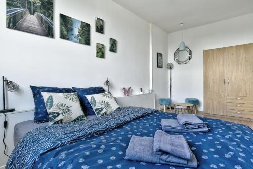 a bedroom with a bed with blue sheets and pillows at Spacieux & Familial 3 chambres proche gare in Saumur